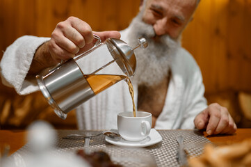 Fototapeta na wymiar Man pouring tea during rest in sauna