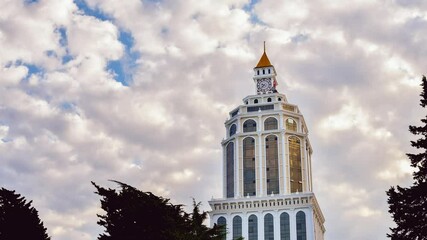 Batumi, Georgia - 15th november, 2021: Time-lapse Sheraton hotel building tower architecture with old clock on top and passing clouds background. Holidays in Batumi, Georgia