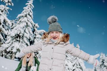 Fototapeta na wymiar cute,blonde child laughs into camera in beautiful snowy landscape.