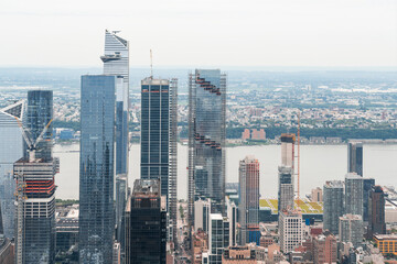 Fototapeta premium Aerial panoramic city view of West Side Manhattan and Hudson Yards district at day time, NYC, USA. New Jersey on horizon over the Hudson River. A vibrant business neighborhoods.