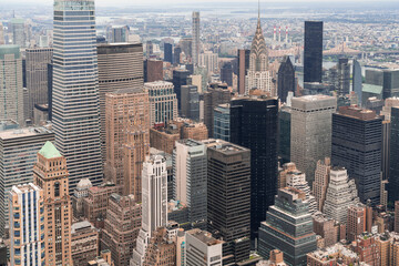 Zoom in aerial panoramic city view of Upper Manhattan area, the East Side, river and Brooklyn neighborhoods on horizon, New York city, USA. Iconic cityscape of building exteriors of NYC