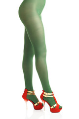 Side view of female legs in green nylon tights and high-heels on isolated white background