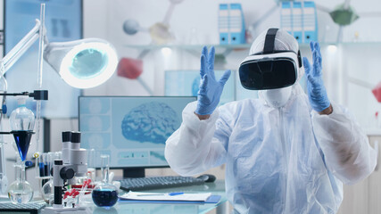 Specialist researcher doctor wearing virtual reality headset analyzing brain activity structure making gestures with hands during biochemistry experiment in microbiology laboratory. Medicine concept - obrazy, fototapety, plakaty