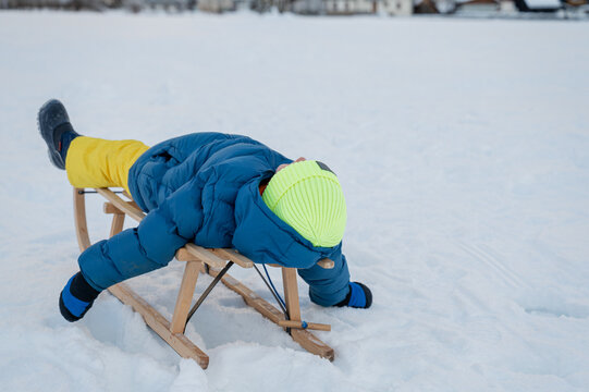 Toddler Boy Lying On Winter Sled Tired