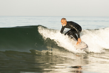 Stunning view of a mature surfer catches a wave - obrazy, fototapety, plakaty