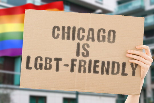 The phrase " Chicago is LGBT-Friendly " on a banner in men's hand with blurred LGBT flag on the background. Human relationships. different. Diverse. liberty. Sexuality. Social issues. Society