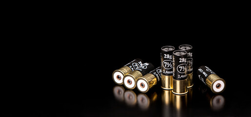 Shotgun cartridges on a black back. Ammunition for smooth-bore weapons. Reflections on a glossy surface.