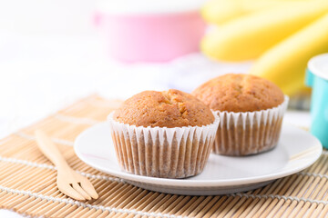 Homemade banana cupcake on white plate with fork ready to eating