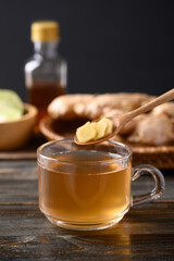 Ginger tea with lime and honey on wooden background, Healthy herbal drink
