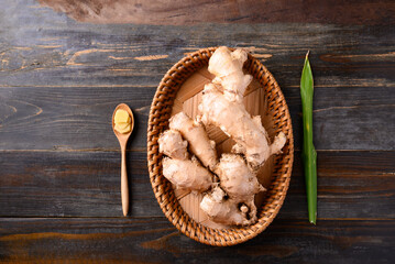 Fresh ginger root in small basket on wooden background, Food ingredient in Asian cuisine, Table top...
