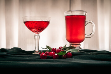 Red fruit flavored cider accompanied by cherries, on an elegant black cloth