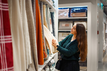 Happy smiling woman making shopping for her new home, walking in store of household goods