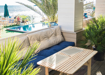 Soft sofa and table in an outdoor cafe with a pool