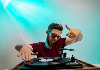 Funny man behind turntable playing music, wearing vintage sunglasses 