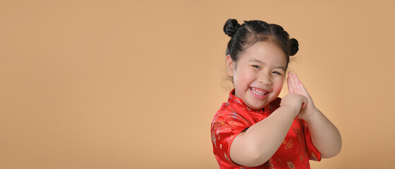 Happy cute little asian girl  wear a red chinese traditional cheongsam with copyspace for the...