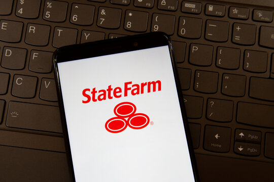 Toronto, On, Canada - December 19, 2021:  State Farm  logo on smartphone screen on a keyboard. State Farm Insurance is a large group of insurance companies throughout the United States.