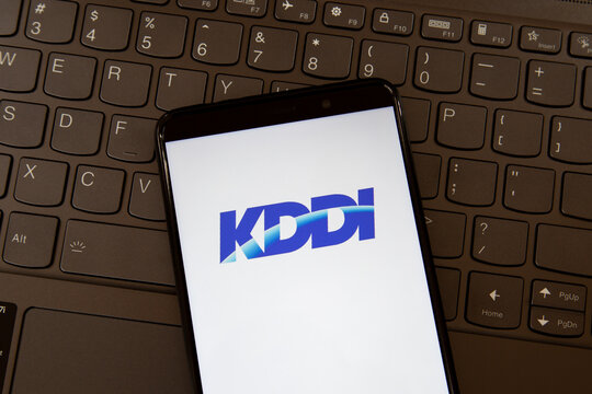 Toronto, On, Canada - December 19, 2021:  KDDI   logo on smartphone screen on a keyboard. KDDI Corporation is a Japanese telecommunications operator. 