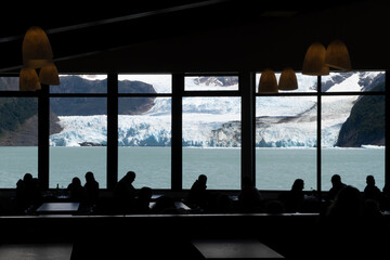 Siluetas en el bar con el glaciar de fondo