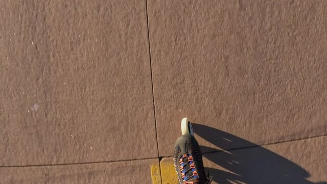 Inline skating on a paved trail, first person POV of skater legs with long shadows