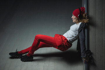 portrait of a hip hop dancer dressed in red in different poses while listening to music on her...
