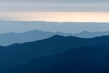 Mountain ridges with the shimmering Pacific ocean in distance.  Shot taken from Mt Lukens in the San Gabriel Mountains area of Los Angeles California.