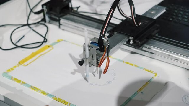 Smart device robot drawing picture, computer execute program, holds blue pen. Innovation in art, robotic digital machine draw on a sheet of paper, no intellectual property for picture or device