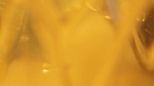 Vegetable oil in motion. Yellow liquid close up.