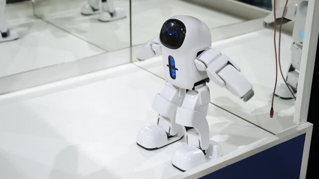 Innovative electronic robot is moving, dancing. White small futuristic robot performs movements. Smart invention and modern technology with no logo and no intellectual property rights