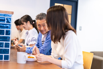 レストランのカウンター席でご飯を食べる人々