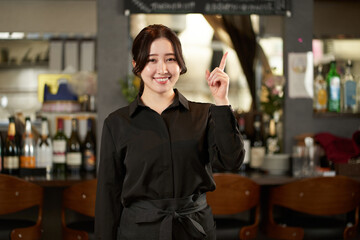 レストランで指差しをするアジア人の女性