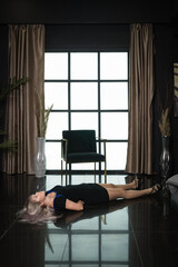 Crime scene simulation: dead girl with hands tied lying on the floor. She was strangled with a...