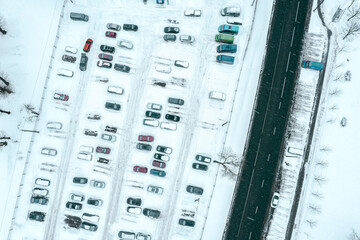 aerial top view of snow-covered urban parking lot during heavy snowfall. aerial overhead view.