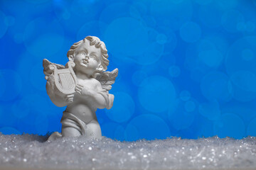 Ceramic angel statue standing on snow 