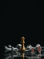 The gold queen chess piece standing with falling silver pawn chess pieces on chessboard on dark background with copy space, vertical style. Leadership, winner, competition, business strategy concept. © tete_escape