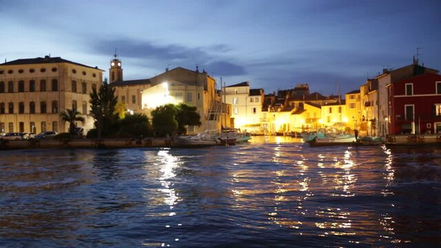 Picturesque evening view of coastal town of Martigues divided by canals with colorful residential buildings along waterfronts in summer, France