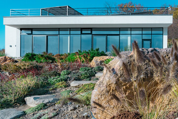 Facade of a modern private house made of glass and concrete on a mountain by the sea