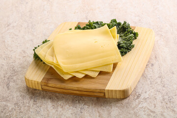 Sliced Gouda cheese over board