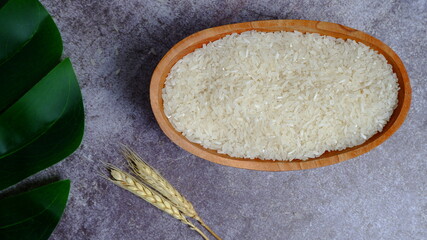 Rice in an oval wooden bowl and some kitchen ornaments neatly and beautifully arranged on a table. food and beverage concept. High angel view. Flat lay.