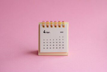 Desktop calendar for April 2022 on a yellow background.