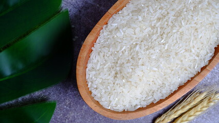 Rice in an oval wooden bowl and some kitchen ornaments neatly and beautifully arranged on a table. food and beverage concept. High angel view. Flat lay.