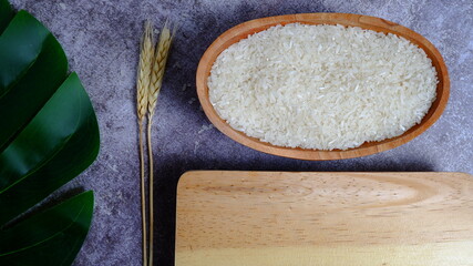 Rice in an oval wooden bowl and some kitchen ornaments neatly and beautifully arranged on a table. food and beverage concept. High angel view. Flat lay.