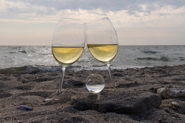 Romantic glass of white wine, on the sea beach. Wine tasting and relaxation at the resort