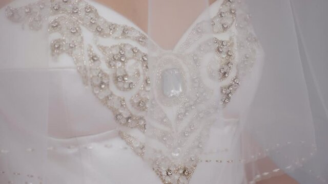 Close-up portrait of a bride in a dress with a veil that covers her head. Portrait of the bride with bright makeup on a white background.