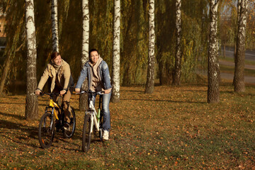 walk in the woods . a man and a woman ride bicycles in the park
