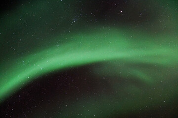 Night starry sky with Aurora Borealis beautiful green lights in Kvaloya, Arctic region, Norway