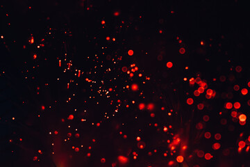 Fototapeta na wymiar Glittering festive red and black background. Concept of New Year celebration. defocused blurred background. Sparkling magical dust particles.