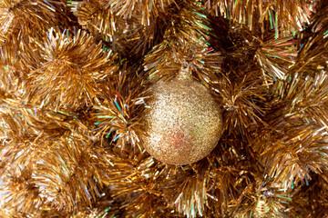 Obraz na płótnie Canvas Fir branch with balls and festive lights on the Christmas background with golden sparkles.