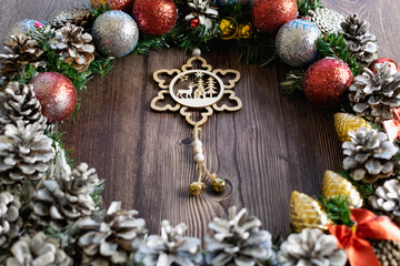 Obraz na płótnie Canvas Christmas composition on a wooden background, Christmas cones and balls, green sprigs of needles, yellow lanterns in the form of stars and space for text, beautiful decoration for the home and design