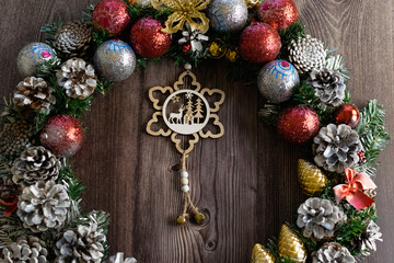 Christmas composition on a wooden background, Christmas cones and balls, green sprigs of needles, yellow lanterns in the form of stars and space for text, beautiful decoration for the home and design