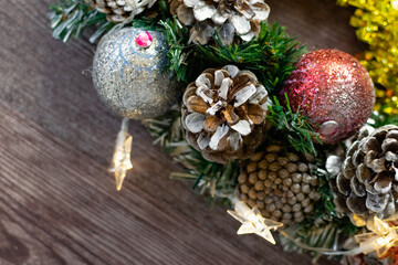 Christmas composition on a wooden background, Christmas cones and balls, green sprigs of needles, yellow lanterns in the form of stars and space for text, beautiful decoration for the home and design